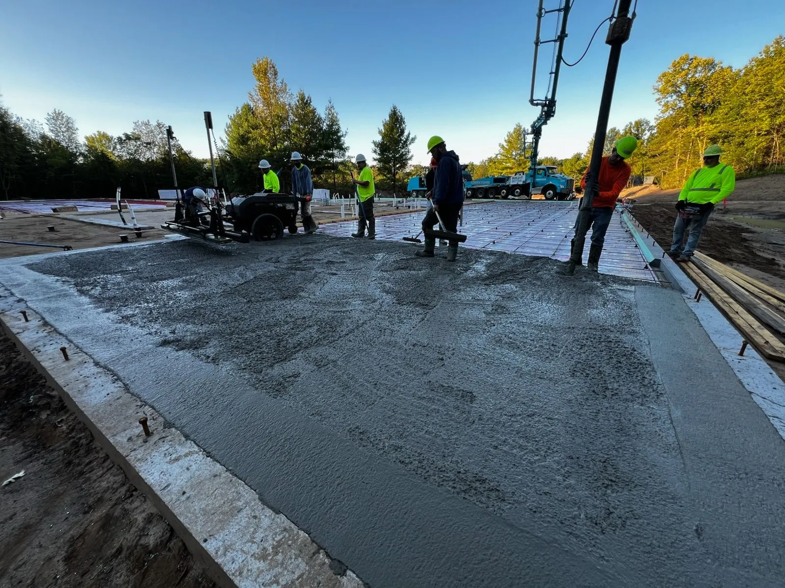 Crew placing and screeding concrete with laser screed