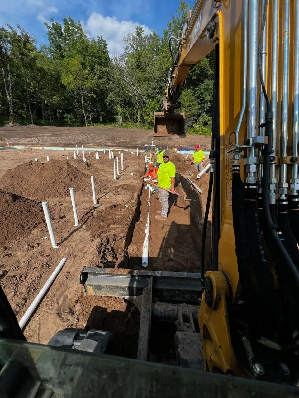 Crew installing underground sewer lines with excavator