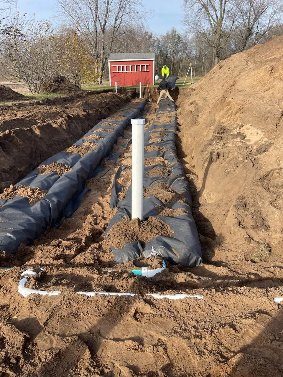 Septic drain field trenches with fabric and risers